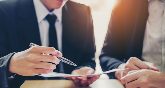 Two Businessmen Reviewing Documents at a table.